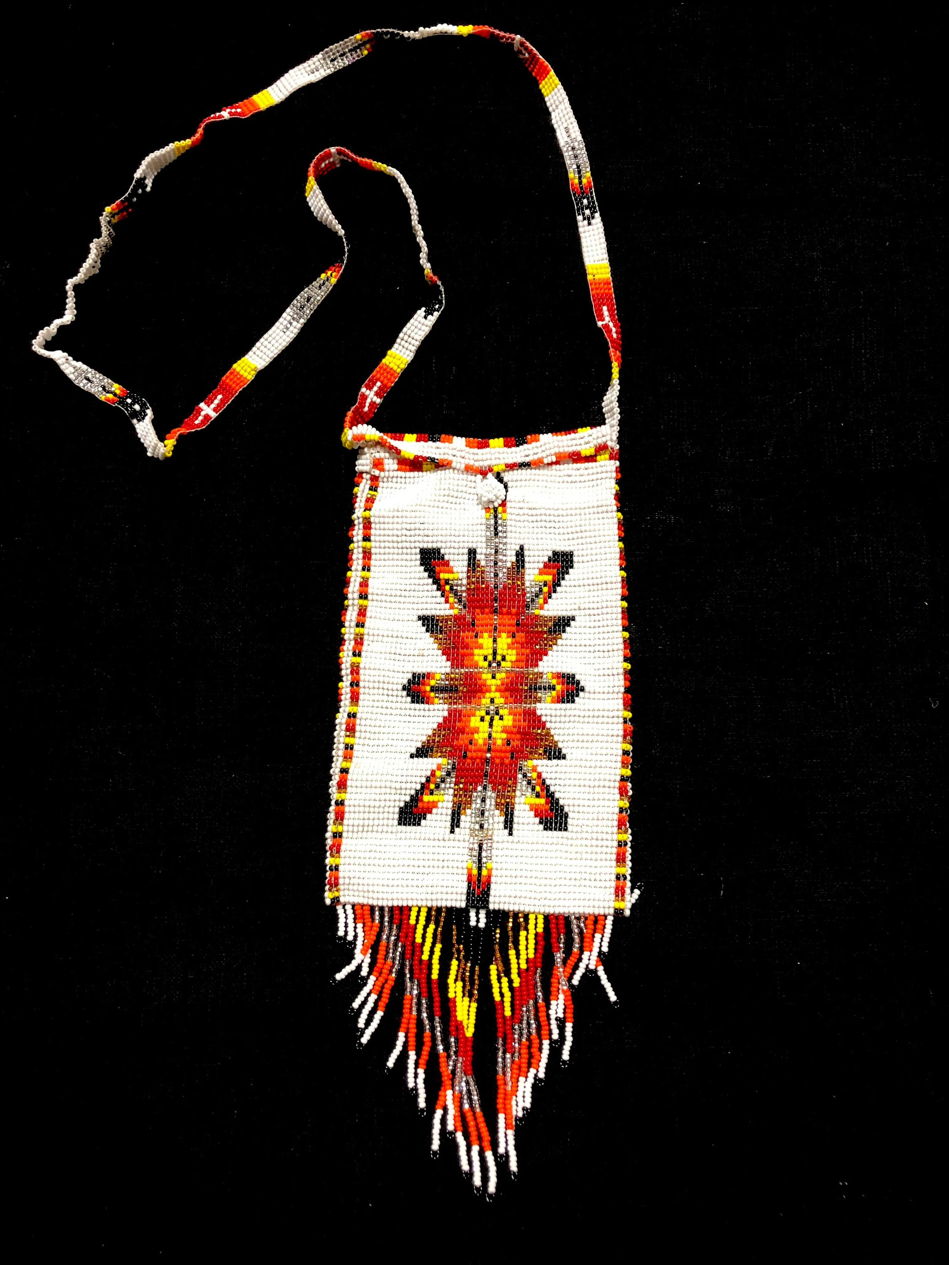 Guatemalan handcrafted glass bead shoulder bag, approximately 4” x 7” with a 32 inch strap.  The bags are decorated on both side